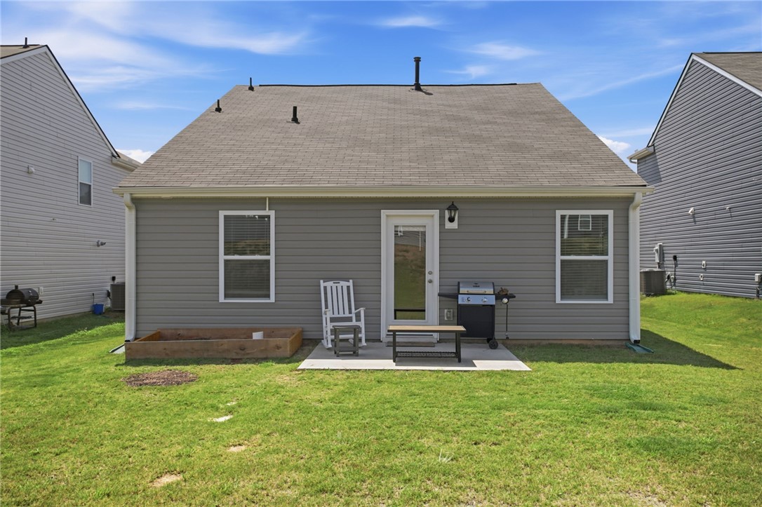 216 Boxbury Way Fountain Inn, SC 29644 - Photo 24 of 28 An inviting backyard patio sits adjacent to a green lawn under open skies.