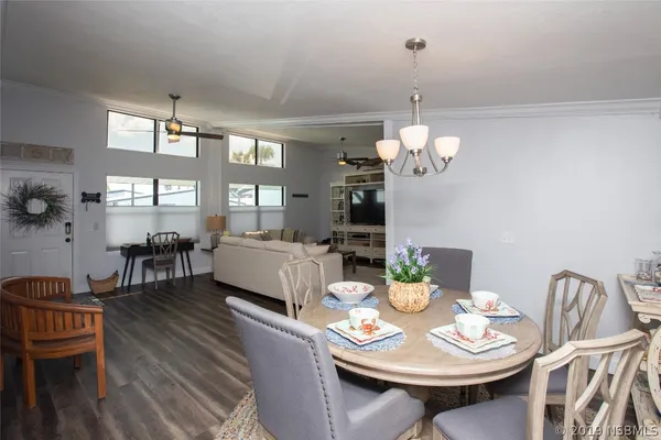 a view of a dining room with furniture a chandelier and wooden floor