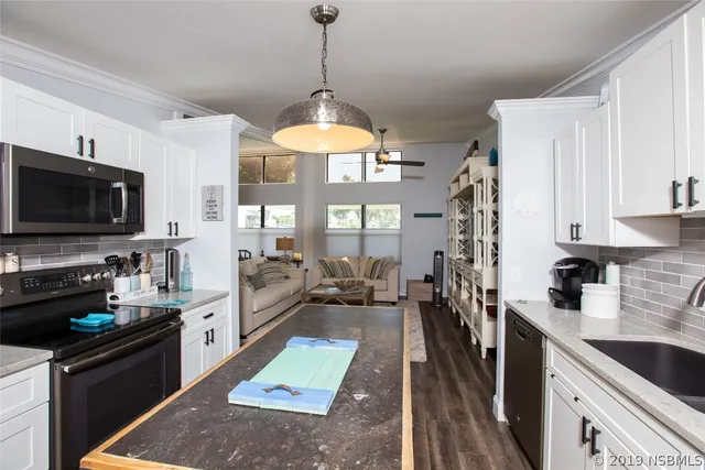 a kitchen with a sink a counter top space appliances and cabinets