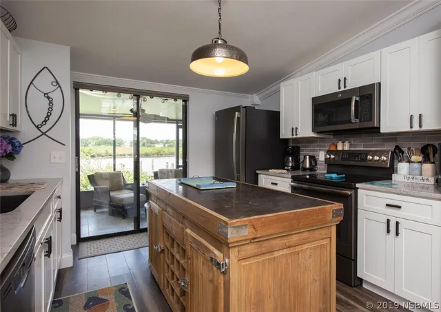 a kitchen with stainless steel appliances granite countertop a stove a sink and a refrigerator