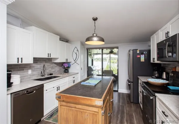 a kitchen that has a sink cabinets counter space and a window
