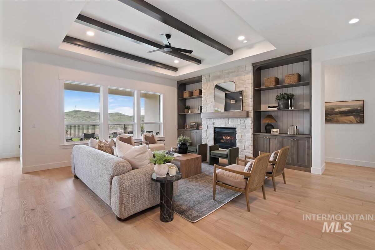 7615 Brown Way Eagle, ID 83714 - Photo 6 of 43 Spacious living area featuring light wood-finish flooring, a tray ceiling with dark wood beams, and recessed lighting