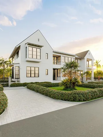 a view of a white house next to a yard with big trees
