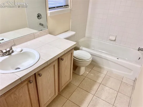 a bathroom with a granite countertop sink a toilet and bathtub