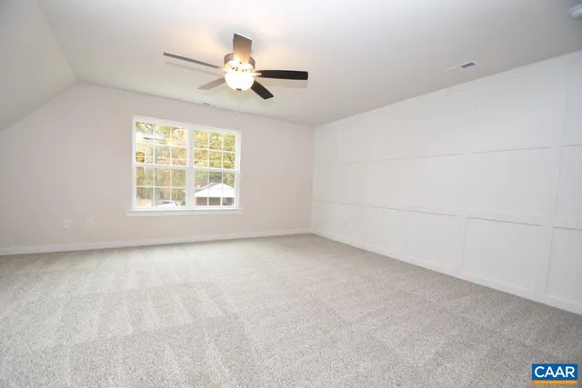 an empty room with a window and a ceiling fan