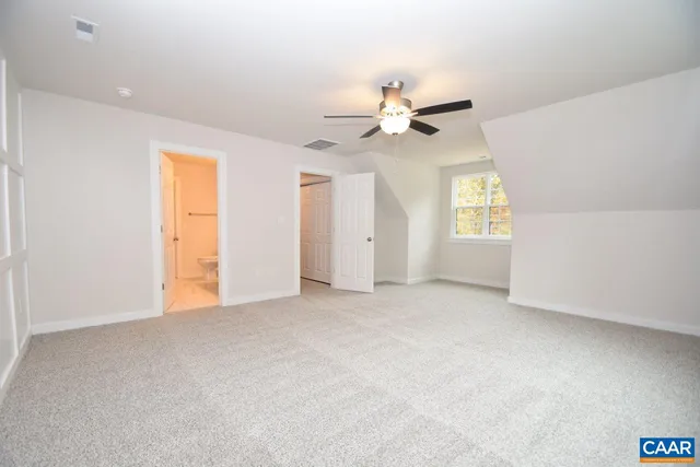 an empty room with windows and ceiling fan