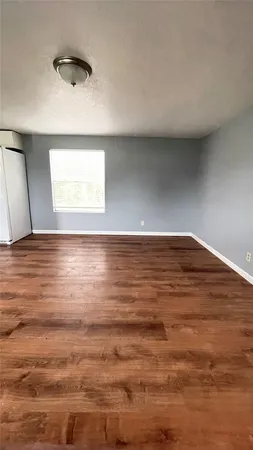 a view of a room with wooden floor and front door