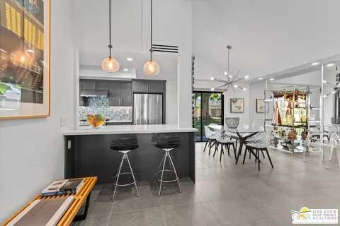 a kitchen with a dining table chairs and large window