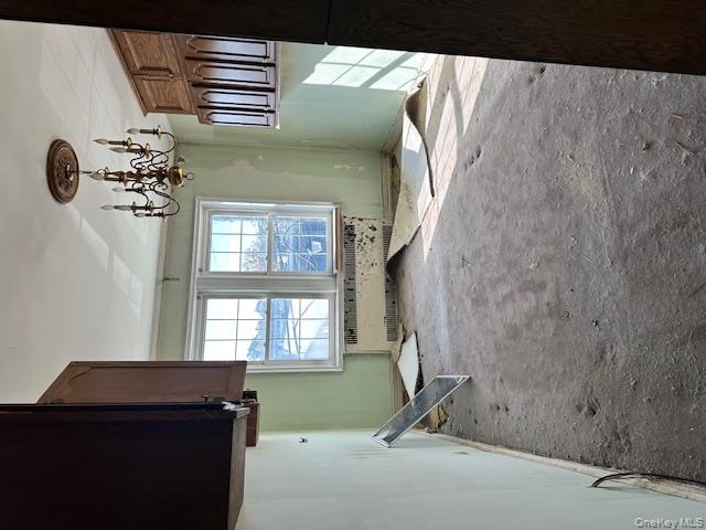 15 Gaynor Avenue, Unit 2H Manhasset, NY 11030 - Photo 6 of 7 Unfurnished dining area featuring carpet flooring, radiator, and a chandelier