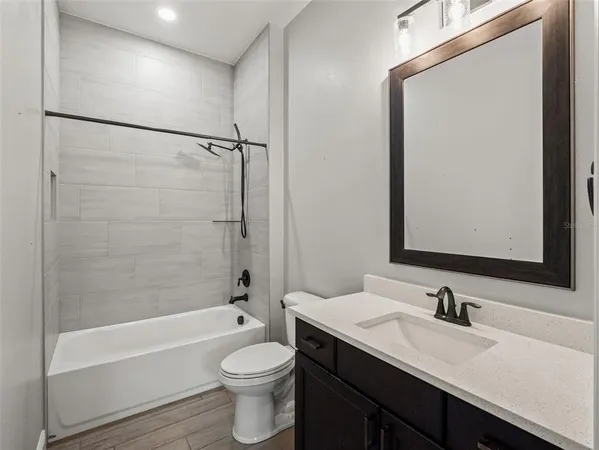 a bathroom with a tub double vanity sink a mirror and a bathtub