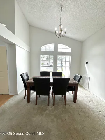 a view of a dining room with furniture and chandelier