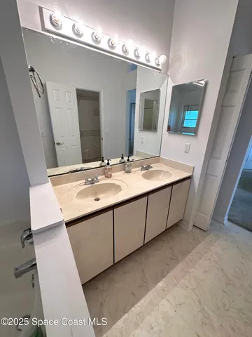a bathroom with a sink double vanity and mirror