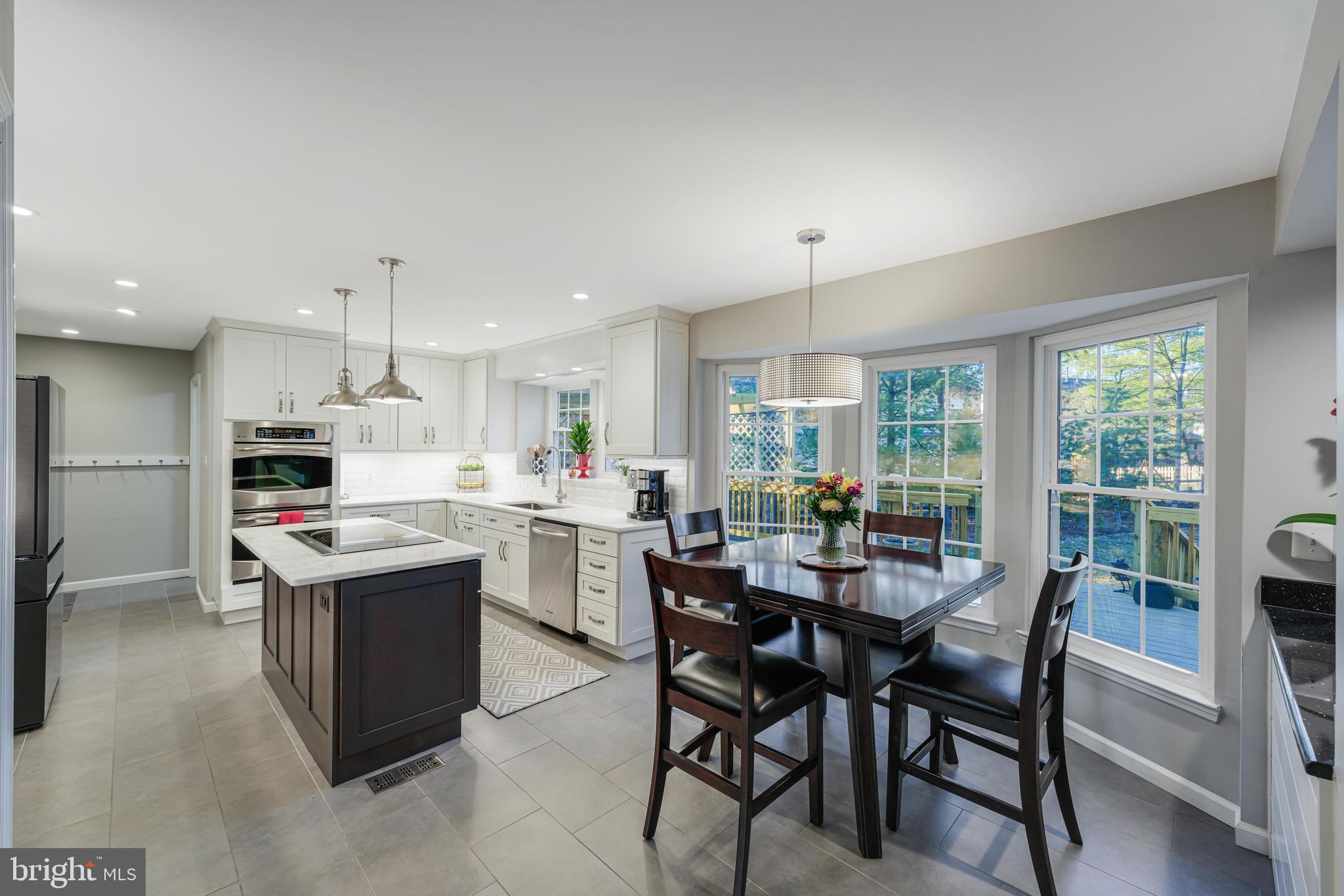 6900 Confederate Ridge Lane Centreville, VA 20121 - Photo 20 of 69 a kitchen view with stainless steel appliances kitchen island granite countertop a table chairs and a view of living room