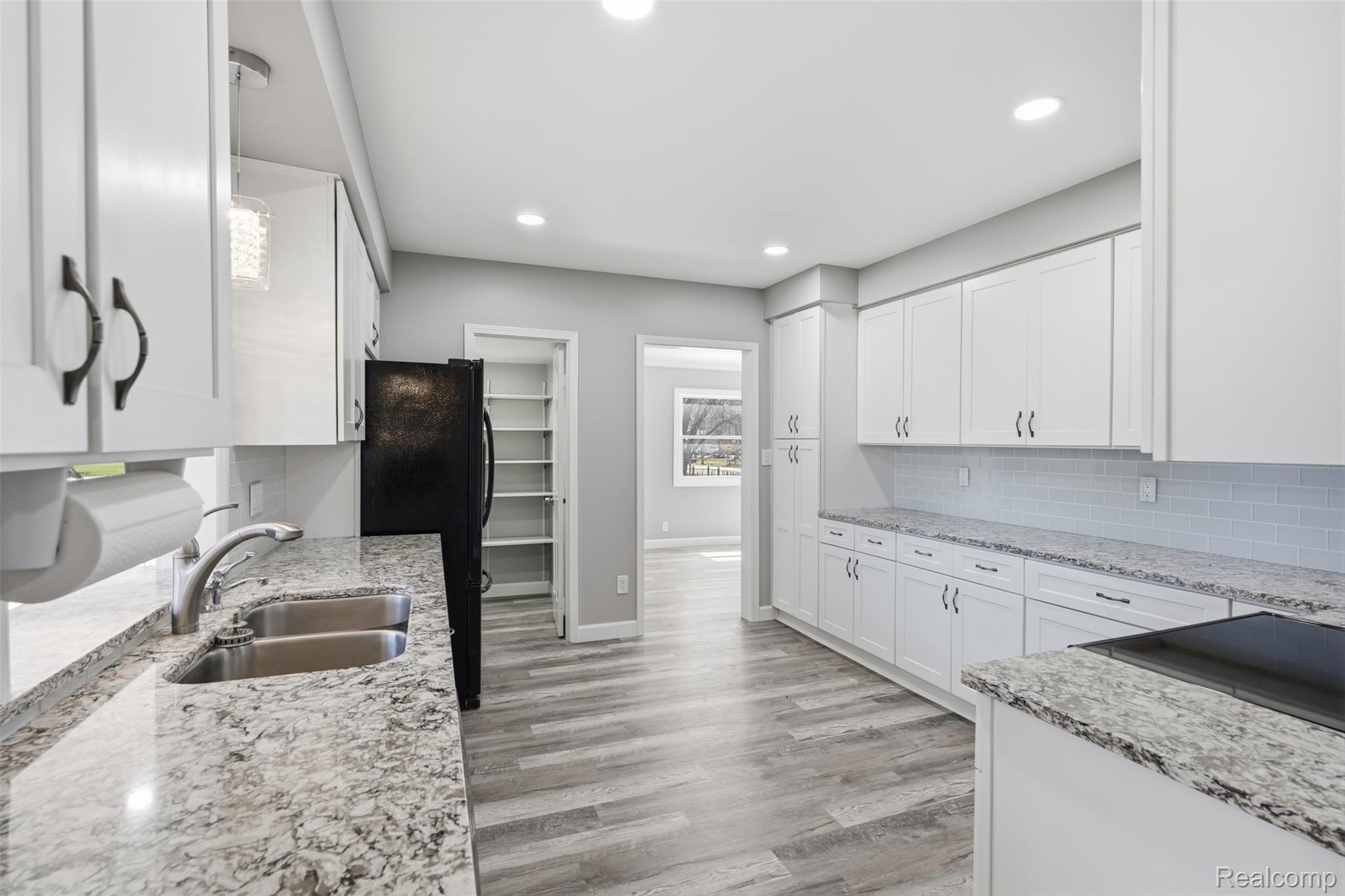 8636 Tindall Road Davisburg, MI 48350 - Photo 16 of 61 Kitchen featuring white cabinetry, light wood-style floors, light stone countertops, recessed lighting, and tasteful backsplash