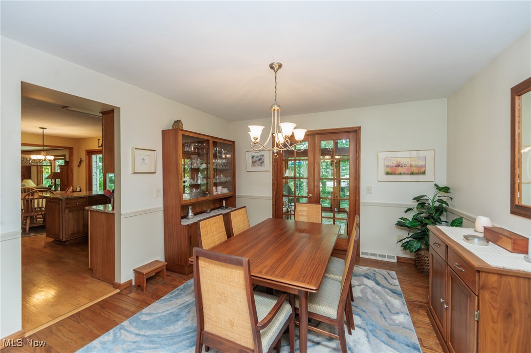 37451 Hunters Ridge Solon, OH 44139 - Photo 7 of 42 Dining area featuring a chandelier, wood finished floors, and healthy amount of natural light