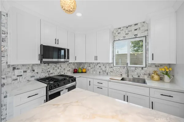 a kitchen with a sink a stove and cabinets