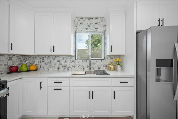 a kitchen with white cabinets and refrigerator