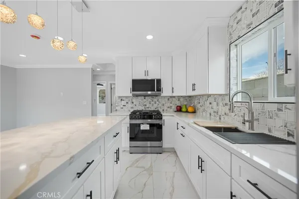 a kitchen with a sink a stove and cabinets