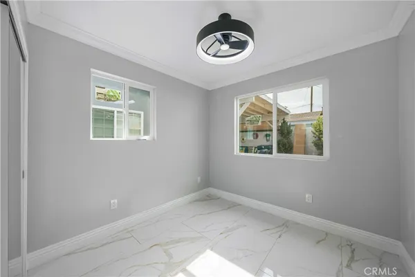 an empty room with windows and fan