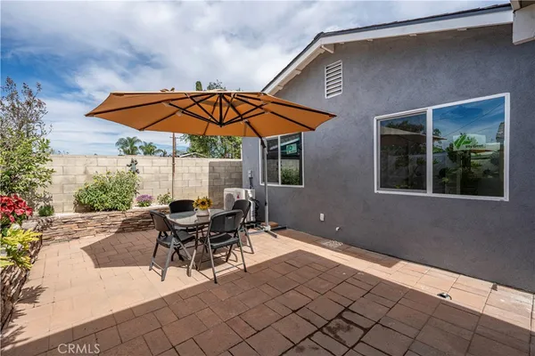 a view of a patio with a table and chairs under an umbrella
