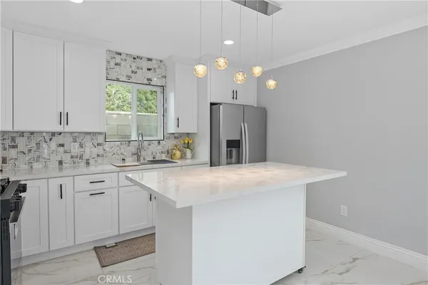 a kitchen with kitchen island a sink stainless steel appliances and window