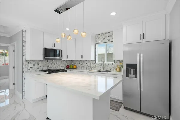 a kitchen with a refrigerator a sink and cabinets