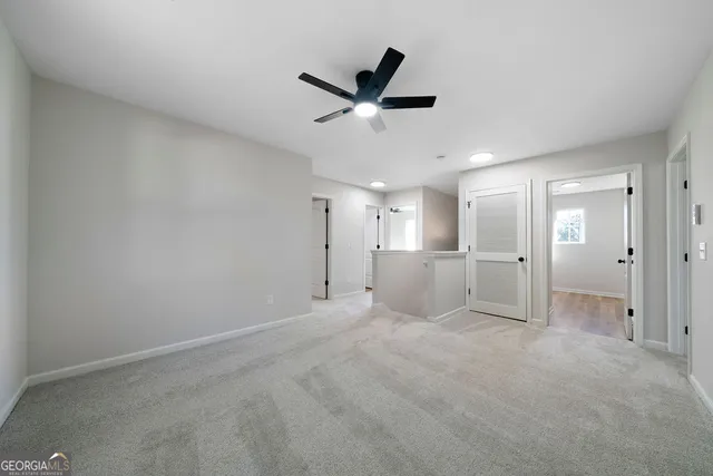 a view of an empty room and kitchen view