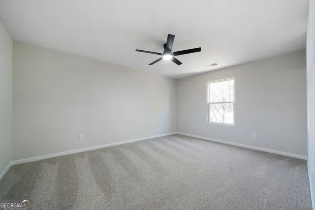 a view of room with a ceiling fan and window