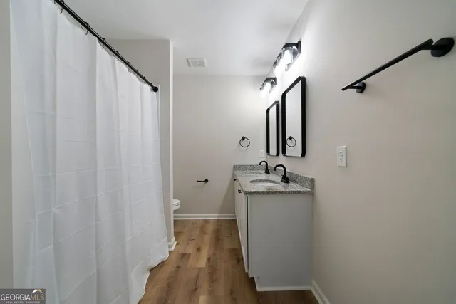 a bathroom with a granite countertop sink vanity and mirror