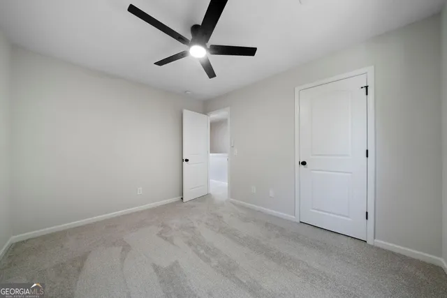 an empty room with ceiling fan and window