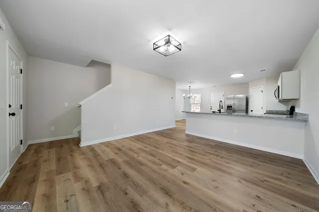a view of an empty room and kitchen view
