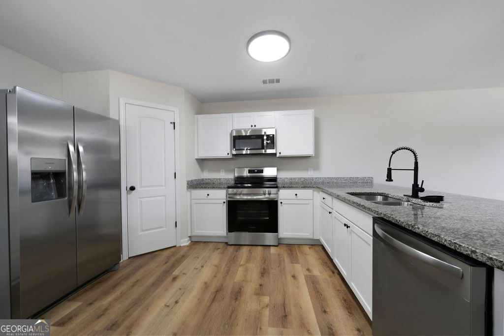 21 Walton Creek Drive Southwest Rome, GA 30165 - Photo 6 of 26 a kitchen with granite countertop a stove top oven and sink