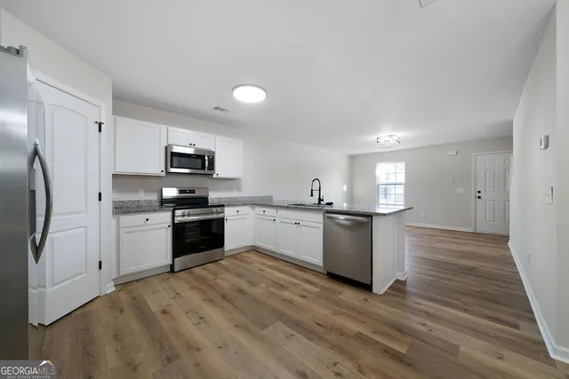 a kitchen with a refrigerator a stove top oven a sink and dishwasher