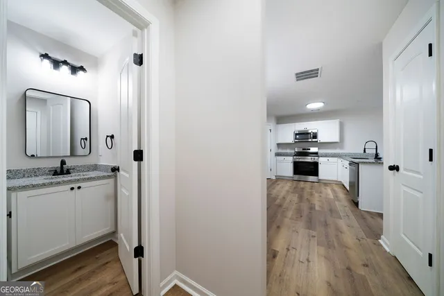 a view of a kitchen with wooden floor and electronic appliances