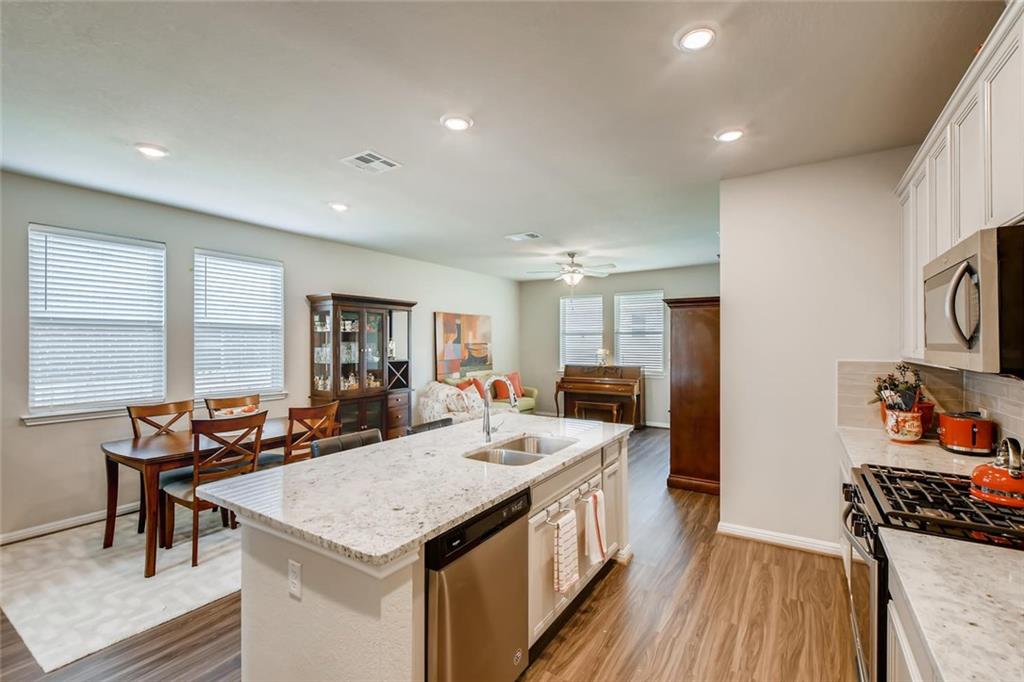 105 Tucana Street Georgetown, TX 78628 - Photo 17 of 17 Kitchen with white cabinetry, dark wood-style floors, an island with sink, appliances with stainless steel finishes, and open floor plan
