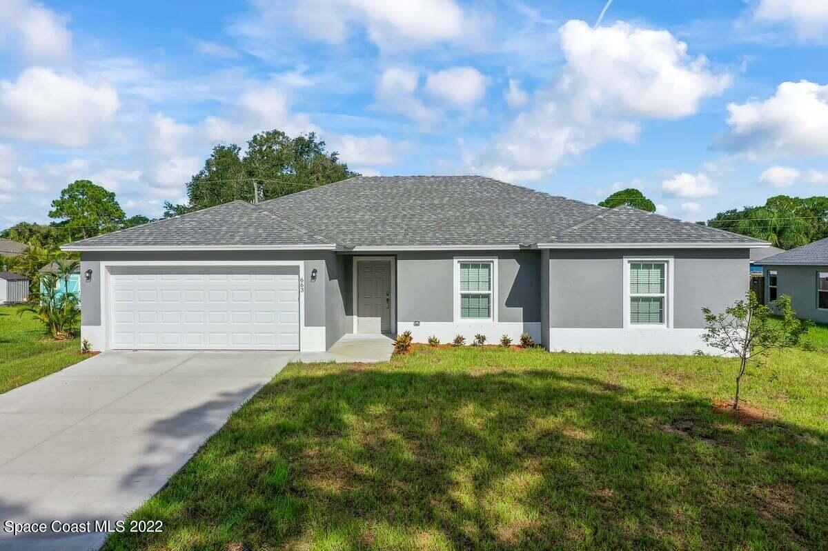 1111 Ver Circle Northeast Palm Bay, FL 32905 - Photo 1 of 30 a front view of a house with a garden and trees