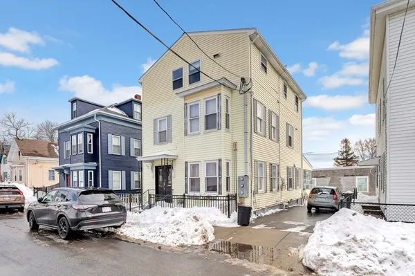 a car parked in front of a white building