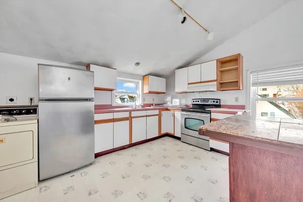 a kitchen with stainless steel appliances granite countertop white cabinets a sink and a stove