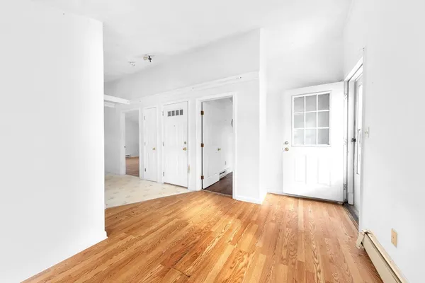 a view of a room with wooden floor and a kitchen