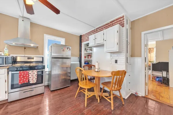 a living room with furniture and a refrigerator