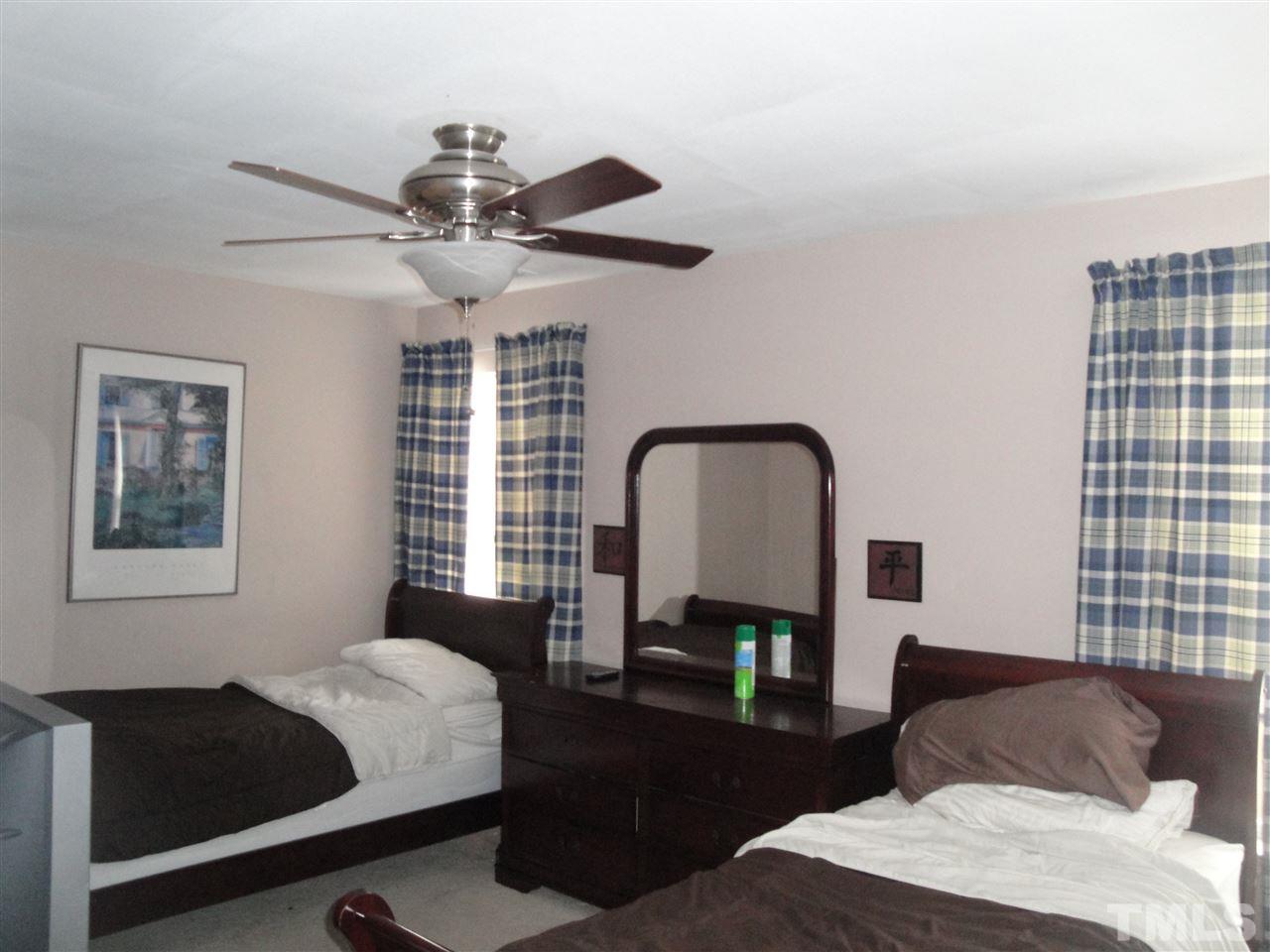 12006 Fox Valley Street Raleigh, NC 27614 - Photo 14 of 25 a bedroom with a bed and a dresser next to a window