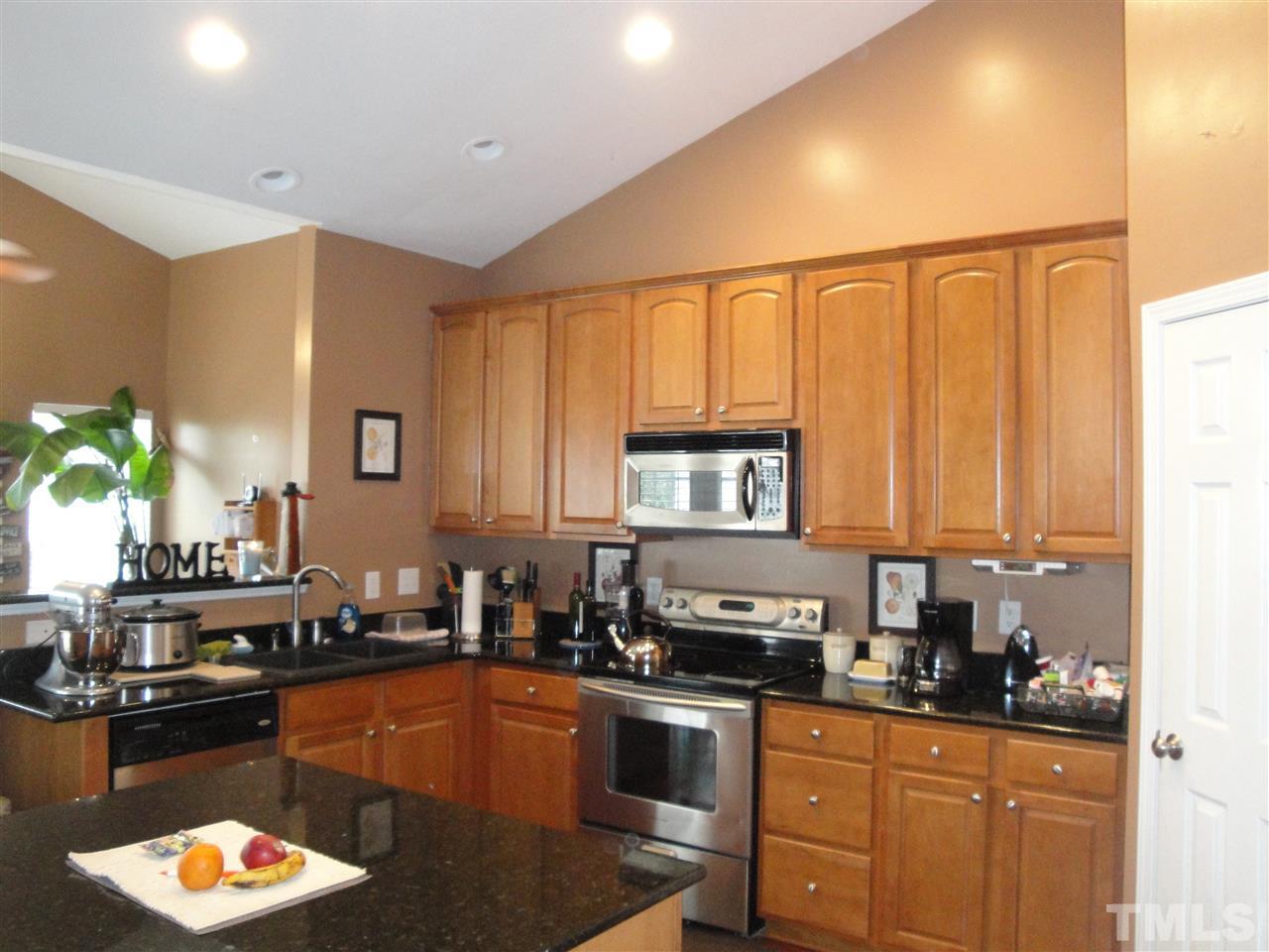 12006 Fox Valley Street Raleigh, NC 27614 - Photo 7 of 25 a kitchen with stainless steel appliances granite countertop a sink a stove cabinets counter space and a window