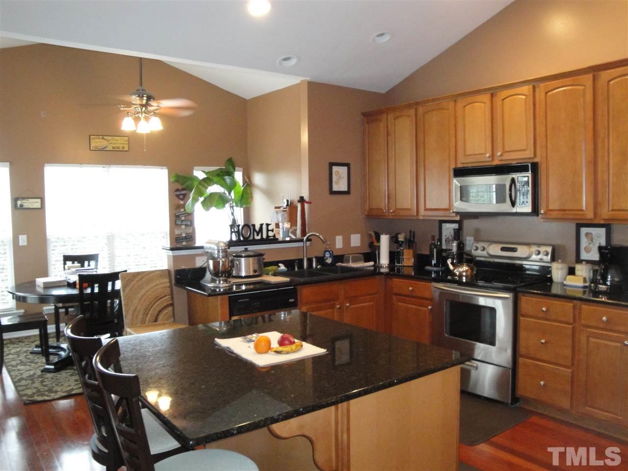 12006 Fox Valley Street Raleigh, NC 27614 - Photo 8 of 25 a kitchen with sink refrigerator dining table and chairs