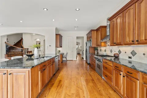 a large kitchen with stainless steel appliances granite countertop a lot of counter space and a sink