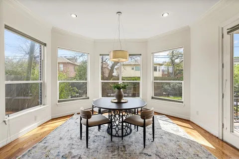a dining room with furniture a chandelier and wooden floor