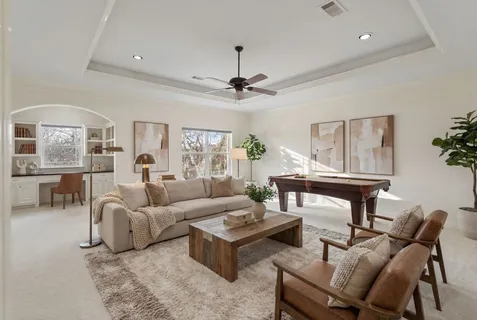 an empty room with windows and chandelier fan