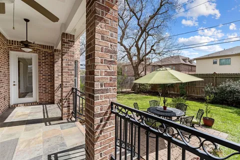 a view of a patio with table and chairs under an umbrella