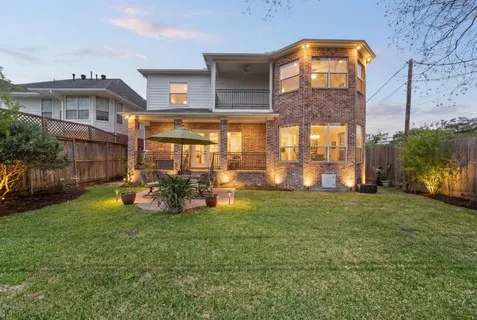 an aerial view of a house with a yard and large tree