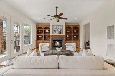 a living room with fireplace furniture and a large window
