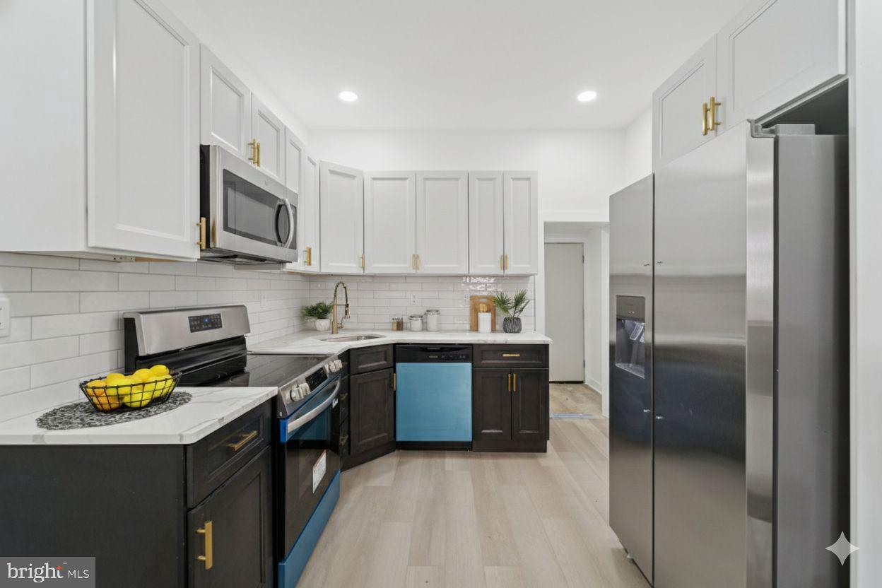 537 North Wanamaker Street Philadelphia, PA 19131 - Photo 11 of 37 a kitchen with stainless steel appliances granite countertop a refrigerator a stove and a sink